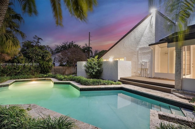 view of pool at dusk