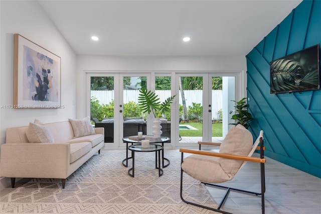 living room with lofted ceiling, a wealth of natural light, and french doors