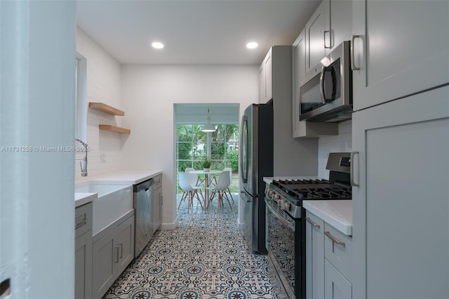 kitchen with backsplash, stainless steel appliances, sink, and gray cabinetry