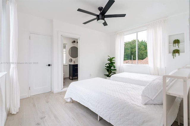 bedroom with ceiling fan, ensuite bath, and light hardwood / wood-style flooring