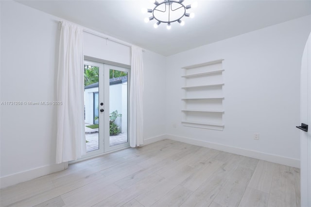 spare room with light hardwood / wood-style floors and french doors