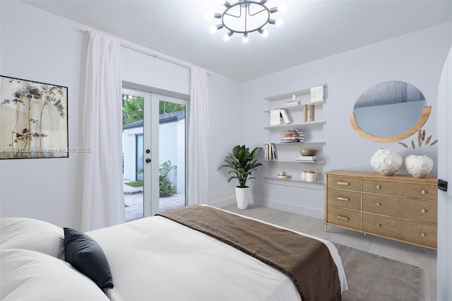 bedroom featuring access to outside, light hardwood / wood-style floors, and french doors