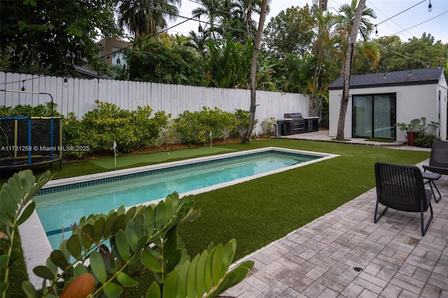 view of pool featuring a grill, an outdoor structure, a patio area, and a lawn