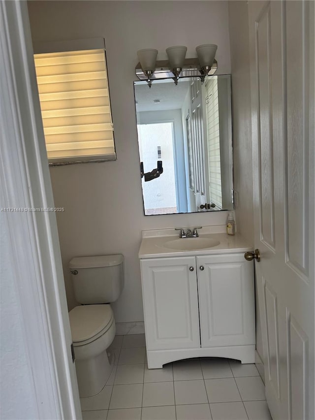 bathroom with tile patterned flooring, vanity, and toilet