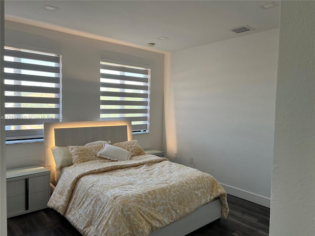 bedroom featuring multiple windows and dark hardwood / wood-style floors