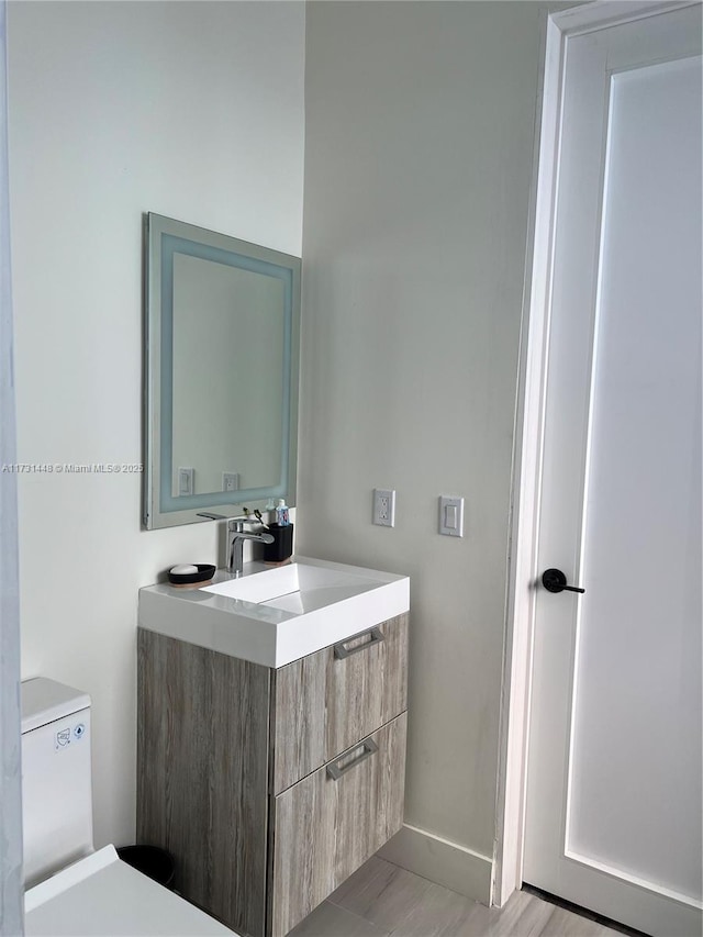 bathroom featuring vanity, toilet, and hardwood / wood-style floors