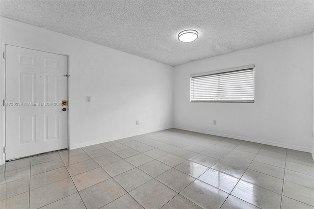 tiled spare room featuring a textured ceiling