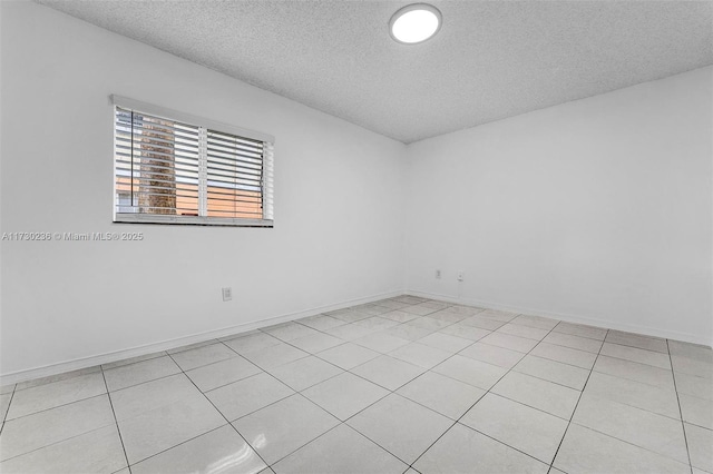 tiled spare room featuring a textured ceiling