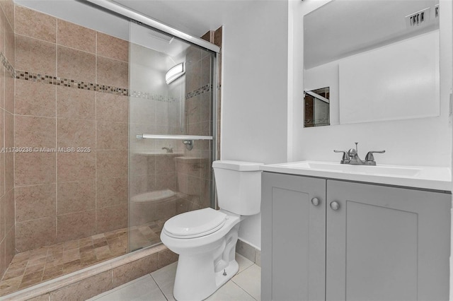 bathroom with tile patterned floors, toilet, a shower with door, and vanity