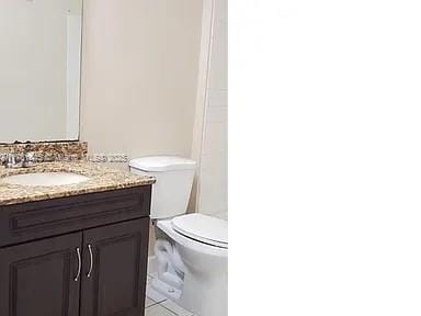 bathroom with vanity, tile patterned floors, and toilet