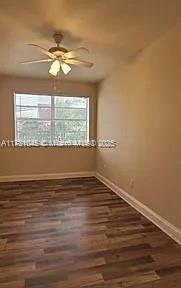 spare room featuring dark hardwood / wood-style floors and ceiling fan