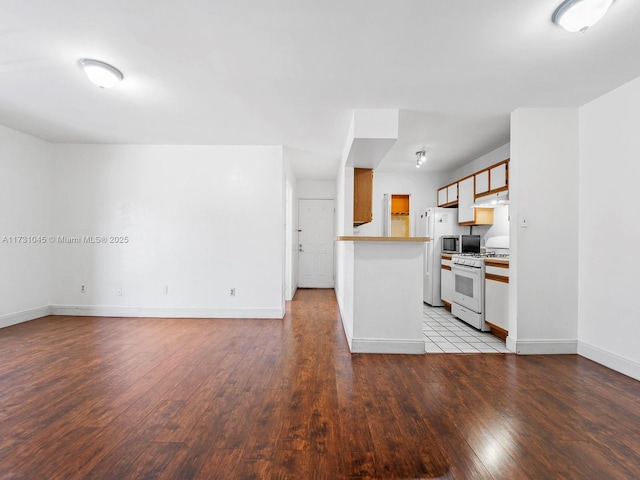 15315 SW 106th Ter Unit 423, Miami, FL 33196 - kitchen with white gas stove, light wood-type flooring, under cabinet range hood, baseboards, and light countertops