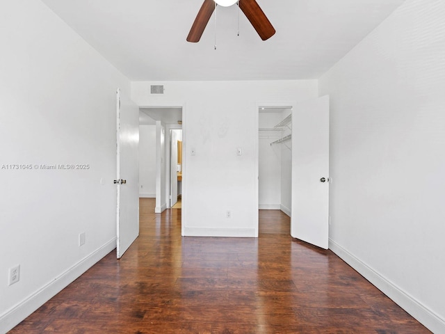 15315 SW 106th Ter Unit 423, Miami, FL 33196 - unfurnished bedroom featuring a walk in closet, wood finished floors, baseboards, and a closet