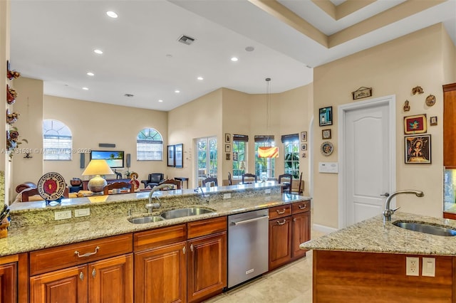 kitchen featuring light stone countertops, sink, stainless steel dishwasher, and pendant lighting