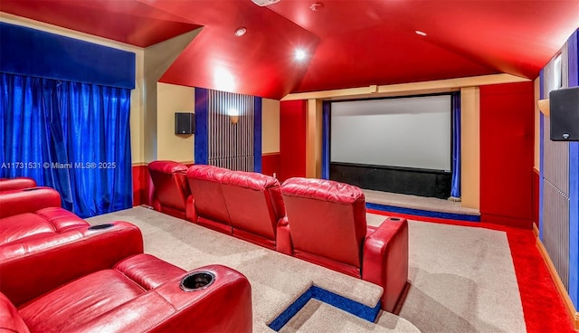 cinema room with carpet floors and vaulted ceiling