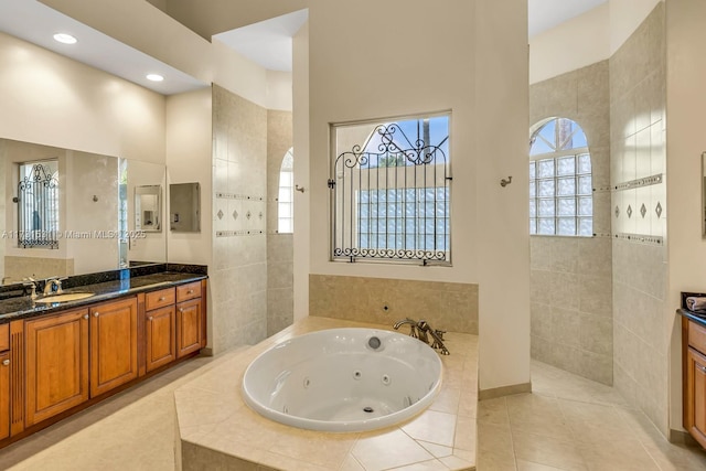 bathroom with tile patterned flooring, vanity, a towering ceiling, and a relaxing tiled tub