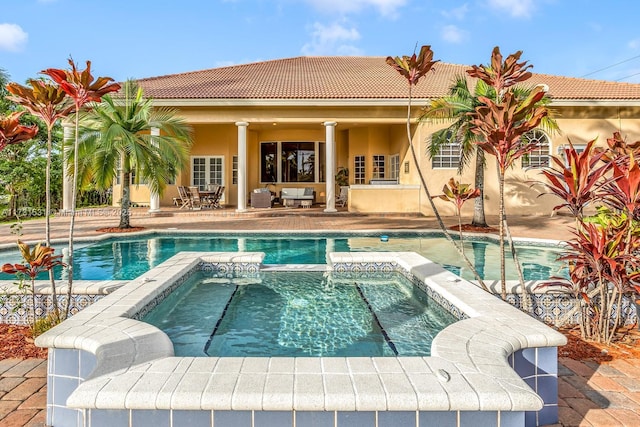 view of pool with a patio and an in ground hot tub