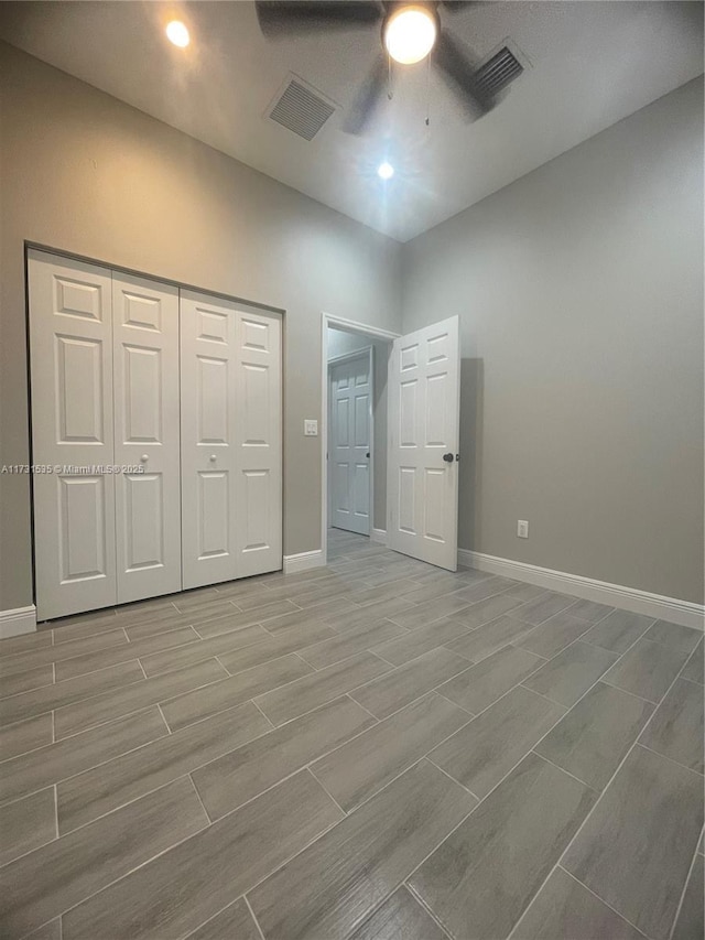 unfurnished bedroom with ceiling fan and a closet