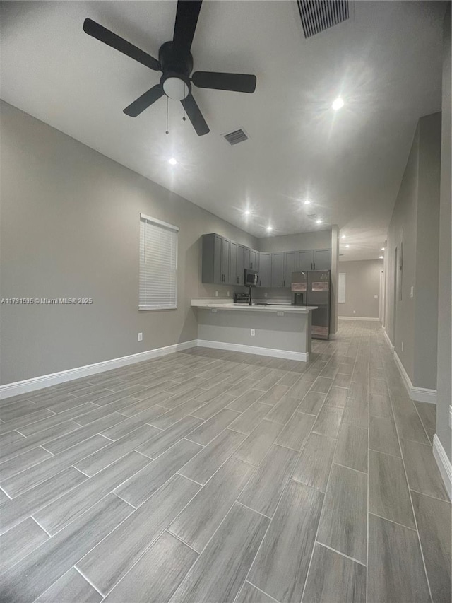 unfurnished living room with ceiling fan