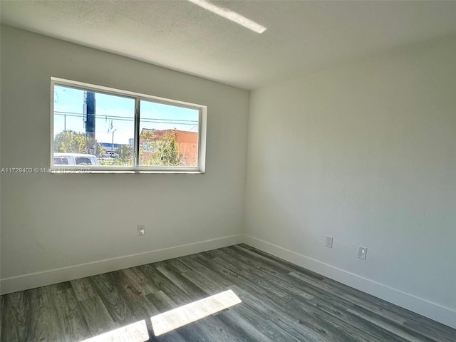 unfurnished room with dark hardwood / wood-style flooring and a textured ceiling