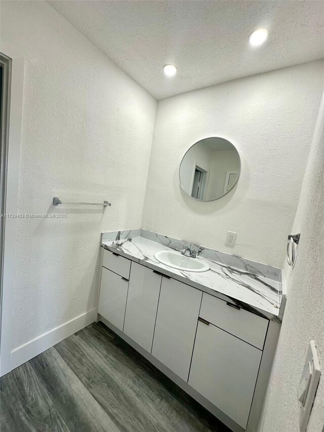 bathroom featuring vanity, hardwood / wood-style flooring, and a textured ceiling