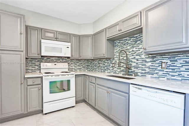 kitchen featuring sink, gray cabinetry, white appliances, and decorative backsplash