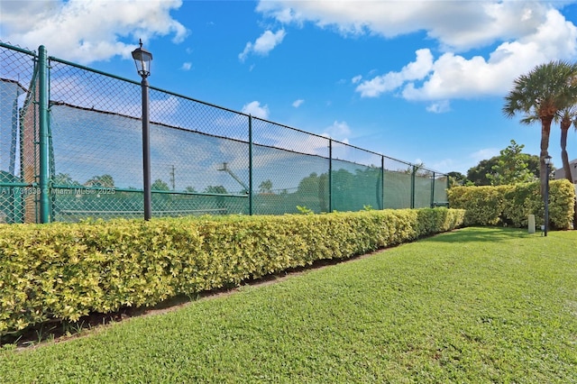 view of sport court featuring a yard