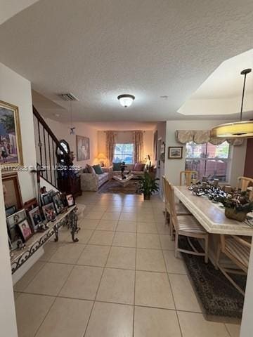 tiled living room with a raised ceiling and a textured ceiling