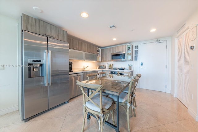 kitchen with light tile patterned floors, stainless steel appliances, and sink