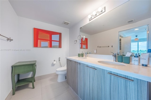 full bath with a sink, visible vents, toilet, and double vanity