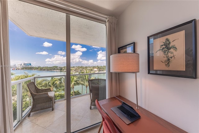 office area featuring a water view, floor to ceiling windows, and tile patterned flooring