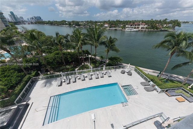 view of pool featuring a water view and a patio