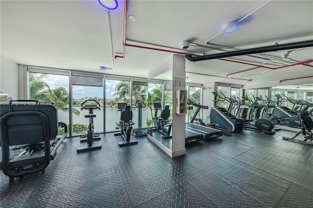 gym featuring a wall of windows and a water view