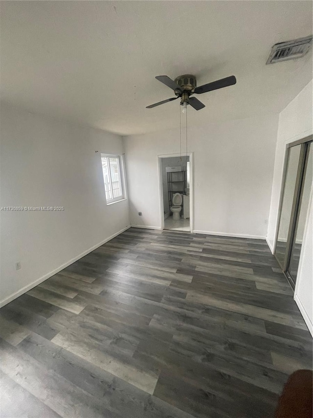 spare room with dark hardwood / wood-style floors and ceiling fan