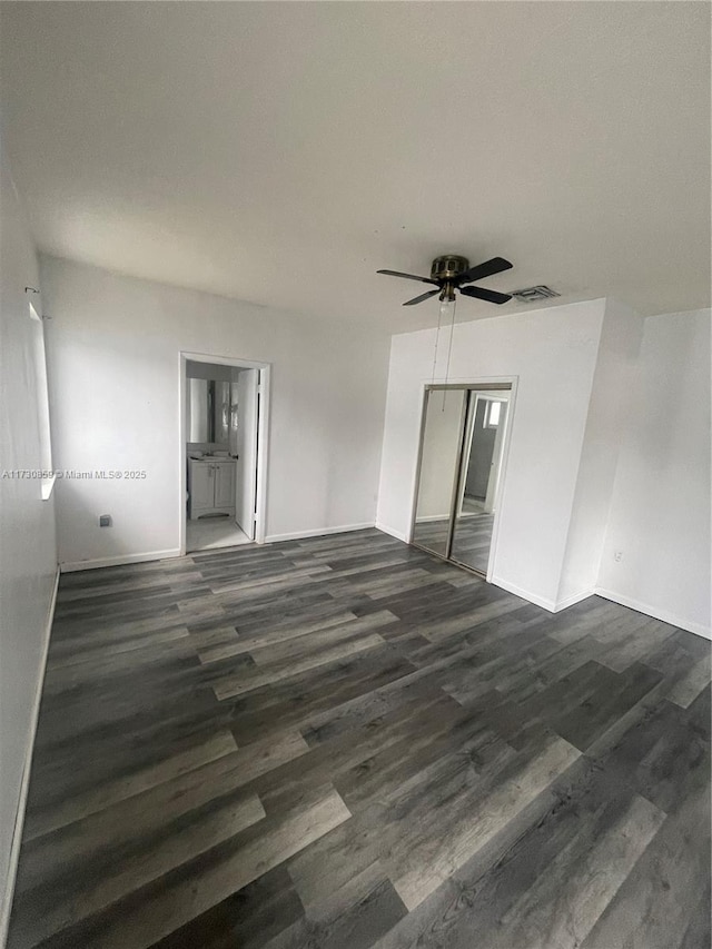 empty room featuring dark hardwood / wood-style flooring and ceiling fan