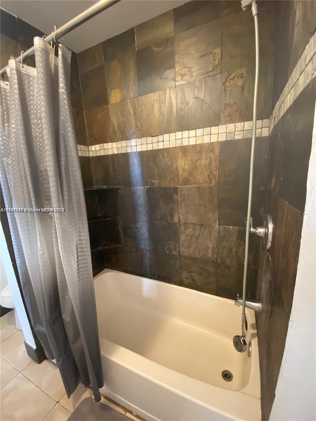 bathroom with tile patterned floors and shower / bath combo with shower curtain