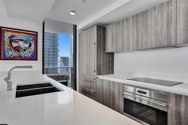 kitchen with sink, black electric stovetop, and oven