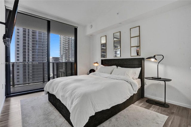 bedroom featuring hardwood / wood-style floors and floor to ceiling windows