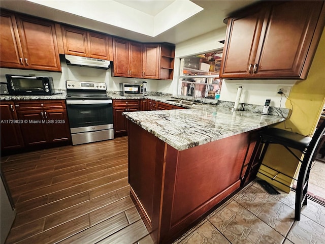 kitchen featuring sink, kitchen peninsula, stainless steel appliances, light stone countertops, and dark wood-type flooring