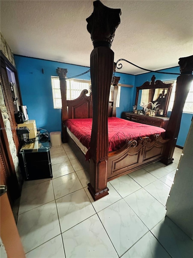 bedroom with marble finish floor and a textured ceiling