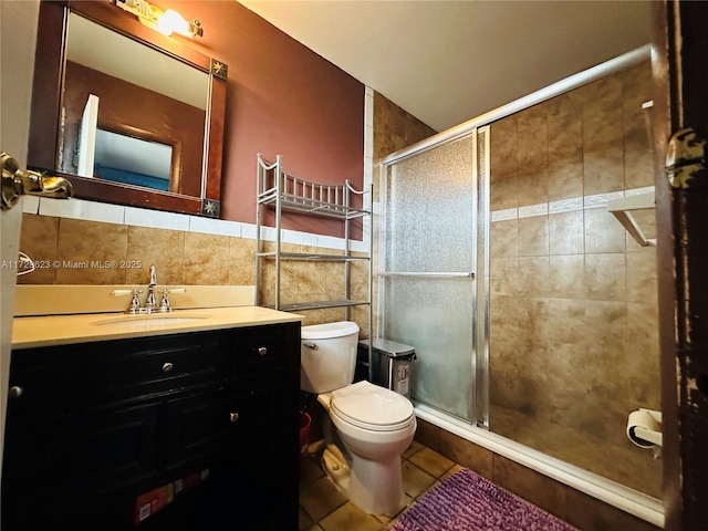 bathroom featuring a stall shower, vanity, tile walls, and tile patterned floors