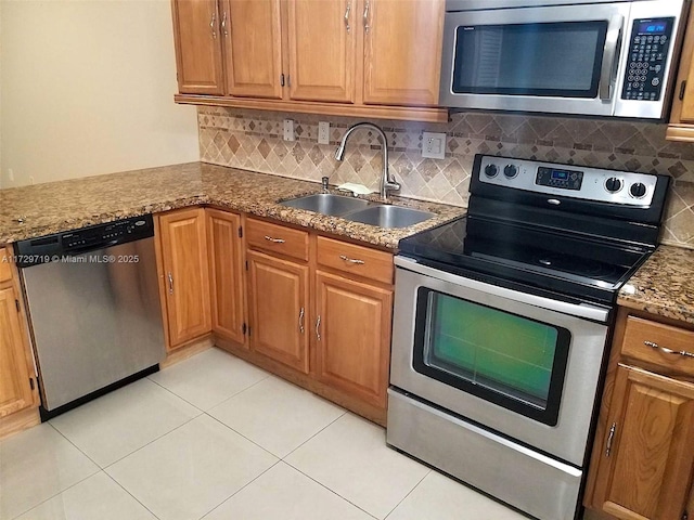 kitchen with sink, light tile patterned floors, stainless steel appliances, tasteful backsplash, and stone countertops