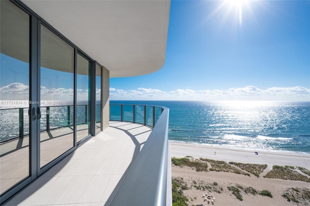 balcony with a water view and a beach view