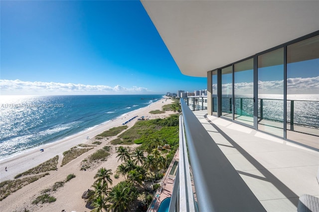 balcony featuring a water view and a view of the beach