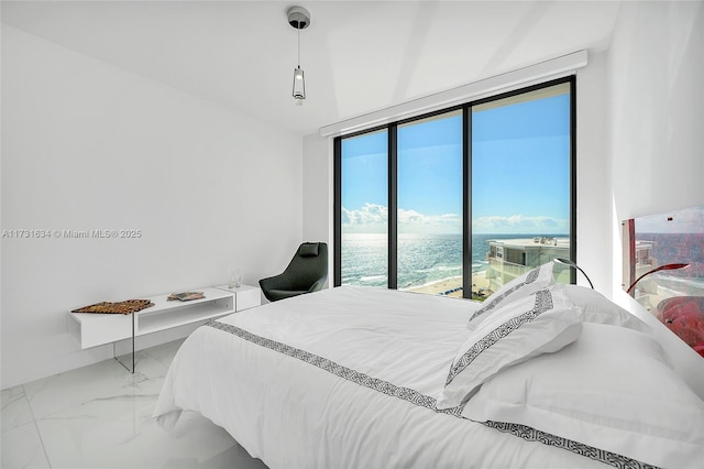 bedroom featuring floor to ceiling windows and a water view