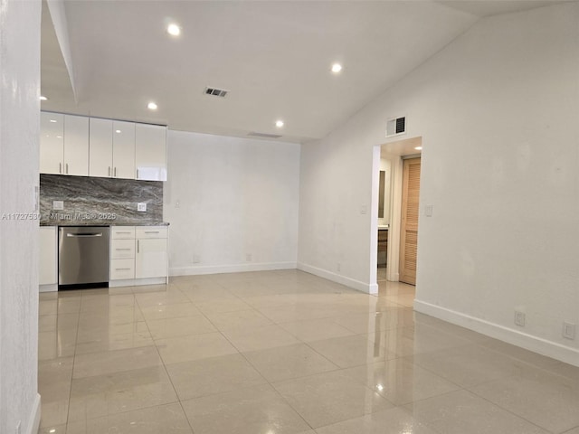 kitchen with white cabinetry, lofted ceiling, stainless steel dishwasher, and decorative backsplash