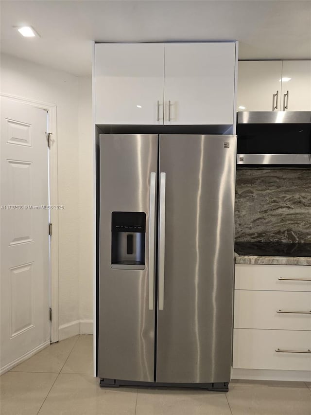 kitchen featuring stainless steel appliances, white cabinetry, and light tile patterned floors