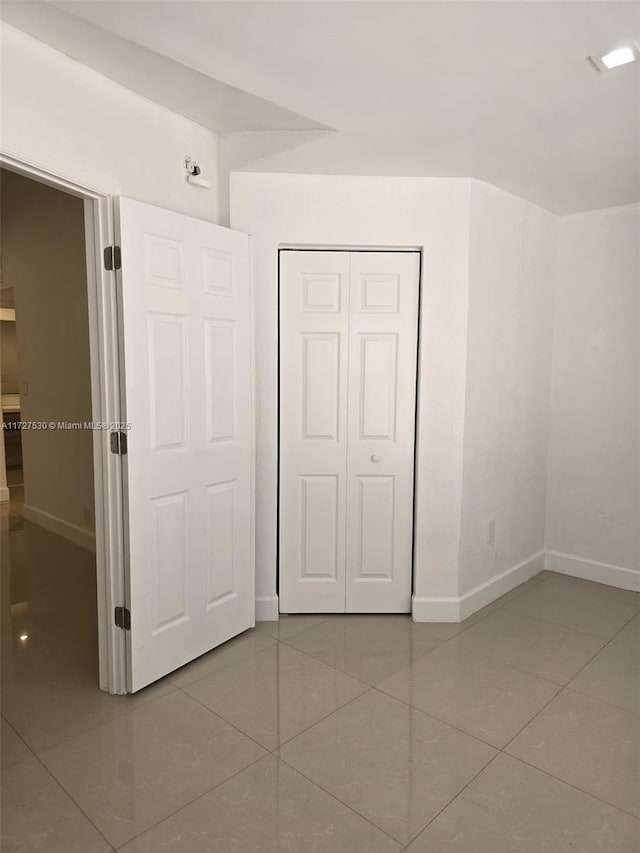 unfurnished bedroom featuring tile patterned flooring and a closet