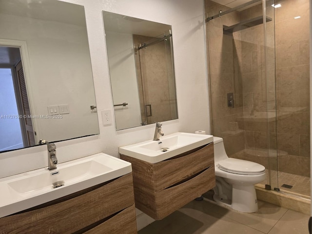 bathroom with vanity, a shower with shower door, tile patterned floors, and toilet