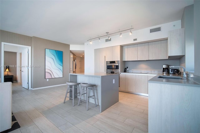 kitchen featuring sink, a center island, black electric stovetop, and a breakfast bar